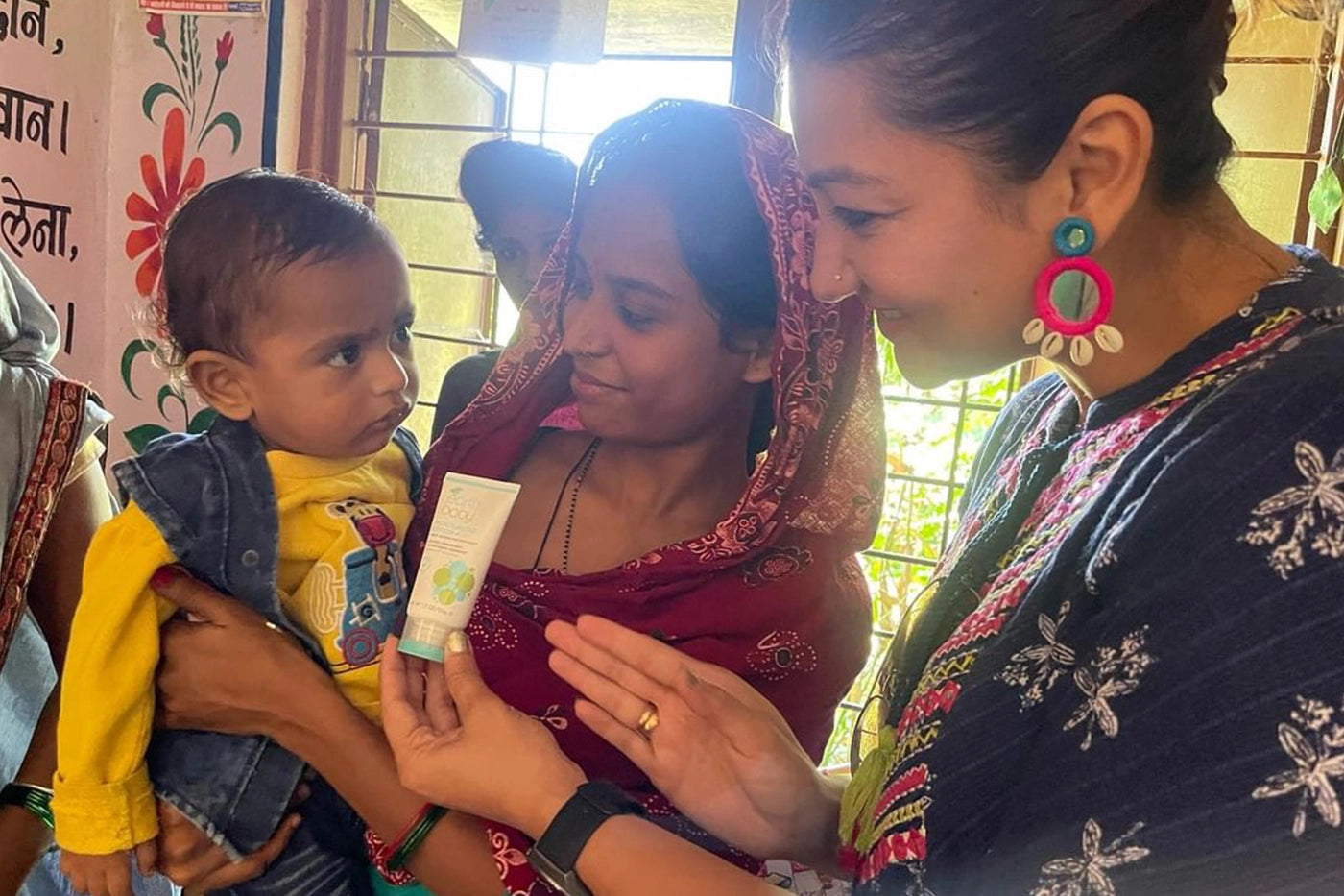 Woman handing out Moisturizing Lotion to small child