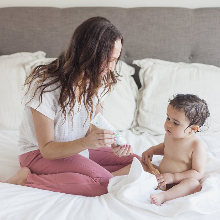 Mom applying Non-Toxic, Hypoallergenic Moisturizing Lotion on baby