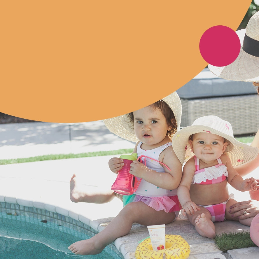 Sunshine Smiles, Shield baby's skin with our Broad Spectrum SPF 30 Sunscreen. Photo of two baby girls sitting next to a pool.
