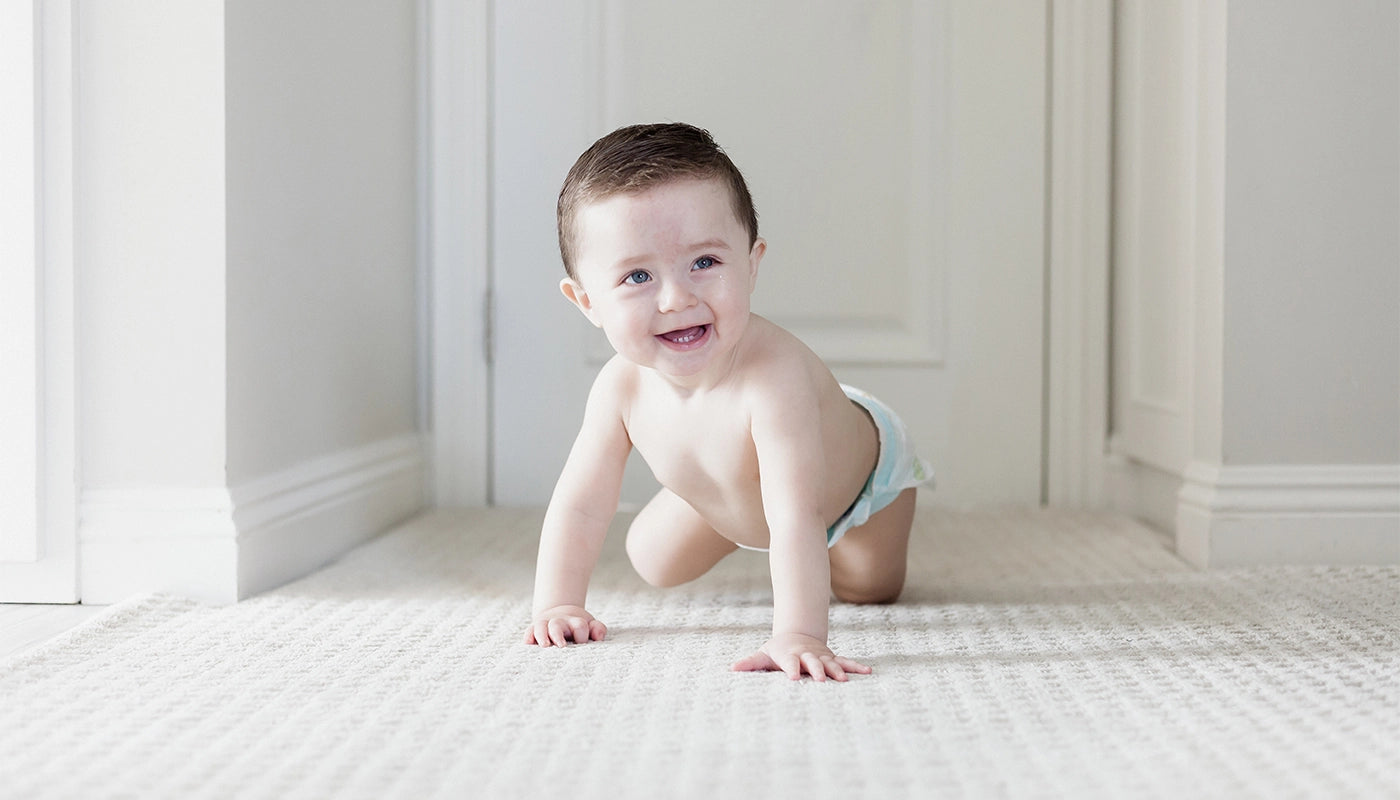 Photo of happy baby crawling on carpet
