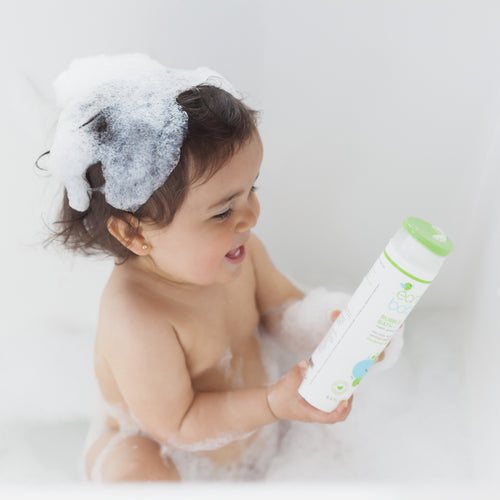 Smiling baby in bubble bath holding Non-Toxic, Hypoallergenic Bubble Bath